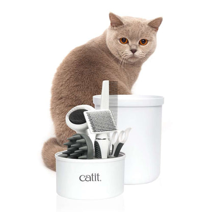 Eine Katze steht hinter dem geöffneten "Catit Kurzhaar-Pflegeset".