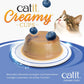 Die "Catit Creamy Cups" der Sorte "Thunfisch, Huhn & Heidelbeeren" in Nah-Ansicht. Eine Katze schaut neugierig.