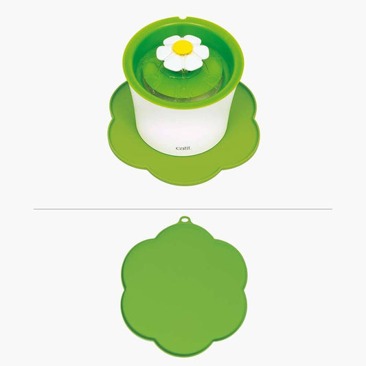 Die grüne "Catit Unterlegmatte BLUME" liegt unter einem Trinkbrunnen.
