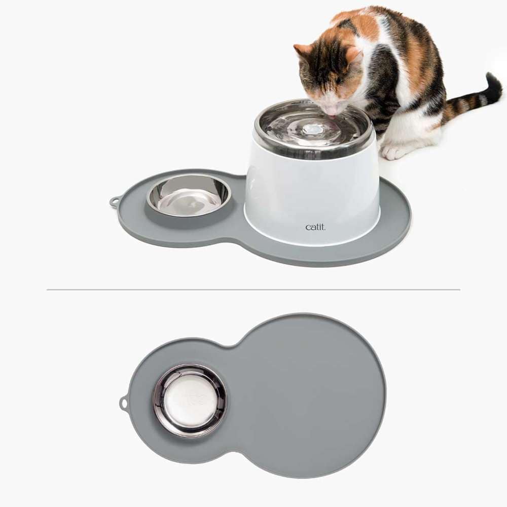 Graue Catit Erdnuss-Unterlegmatte mit Napf. Katze trinkt Wasser.