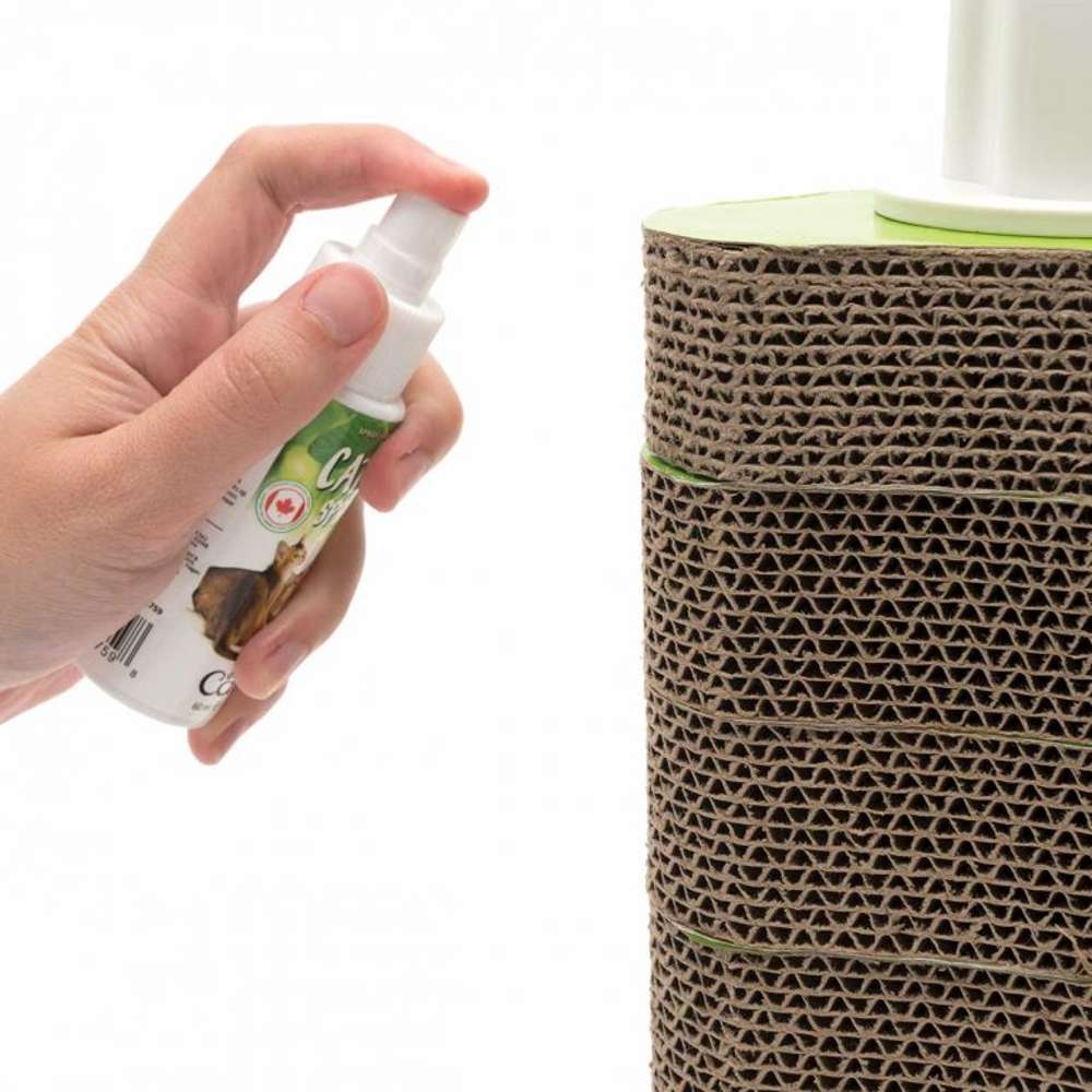 Eine Person sprüht mit dem Spray etwas Katzenminze auf ein Katzenspielzeug.
